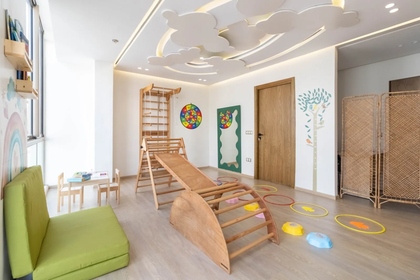 Grande salle de psychomotricité pour enfants avec espalier, toboggan en bois et parcours moteur